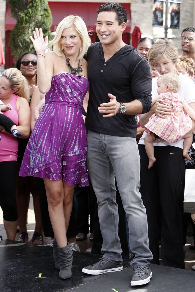 Tori Spelling, purple dress, strapless dress, large necklace, gray boots, Mario Lopez, black shirt, 